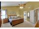 Spacious main bedroom featuring a ceiling fan, sitting area, ensuite bath, and natural light at 7233 Capel Dr, Indianapolis, IN 46259