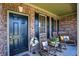 Inviting front porch features rocking chairs, floral arrangements and brick accents at 7233 Capel Dr, Indianapolis, IN 46259