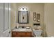 Cozy powder room features a decorative mirror, vanity with storage, and a charming 'Powder Room' sign at 7233 Capel Dr, Indianapolis, IN 46259