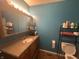 Well-lit bathroom featuring a sink, vanity with drawers, and an adjacent toilet at 731 W Stop 11 Rd, Indianapolis, IN 46217