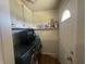 Functional laundry room with washer, dryer, shelving, and convenient access to the backyard at 731 W Stop 11 Rd, Indianapolis, IN 46217