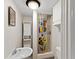 Compact bathroom with a unique shower curtain, sink, and convenient storage at 7341 Campfire Run, Indianapolis, IN 46236
