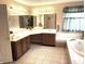 Bathroom featuring double sinks, large mirrors, tile floors, and a soaking tub at 7341 Campfire Run, Indianapolis, IN 46236