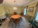 Charming dining room with wood table, chairs, decorative chandelier, and large windows at 7341 Campfire Run, Indianapolis, IN 46236