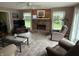 Cozy living room with brick fireplace, tile floors, and natural light from windows at 7341 Campfire Run, Indianapolis, IN 46236