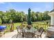 Inviting outdoor patio area, with a table and chairs for entertaining, plus a lush green backdrop at 7341 Campfire Run, Indianapolis, IN 46236