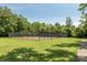 Community tennis court surrounded by a secure fence and mature trees at 7341 Campfire Run, Indianapolis, IN 46236