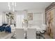 Bright dining area features a sleek, modern white table and chairs, complemented by unique lighting and chic decor at 8926 Poppy Ln, Indianapolis, IN 46231