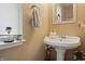 A powder room featuring a stylish pedestal sink, decorative mirror, and elegant fixtures enhancing its charm at 8926 Poppy Ln, Indianapolis, IN 46231