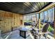Inviting back porch featuring a wood-burning fireplace and relaxing seating area with an outdoor fire pit table at 9334 Seascape Dr, Indianapolis, IN 46256