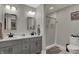 Well-lit bathroom featuring a double vanity, modern fixtures, and a shower with grey tile at 9334 Seascape Dr, Indianapolis, IN 46256