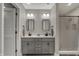 Stylish bathroom featuring double sinks, modern lighting, and a shower with tiling at 9334 Seascape Dr, Indianapolis, IN 46256
