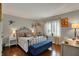Cozy bedroom featuring a metal bed frame, wood floors, bright window and a blue bench at 9334 Seascape Dr, Indianapolis, IN 46256