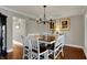 Bright dining room with wood floors, modern lighting fixture, adjacent to living room and entry to hall at 9334 Seascape Dr, Indianapolis, IN 46256