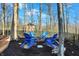 Backyard sitting area with bright blue adirondack chairs around a fire pit, perfect for outdoor gatherings at 9334 Seascape Dr, Indianapolis, IN 46256