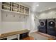 Bright laundry room boasts built-in shelving, bench, and modern washer/dryer units at 9334 Seascape Dr, Indianapolis, IN 46256