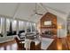 Inviting living room features a brick fireplace, vaulted ceiling, and large windows overlooking the outdoor deck at 9334 Seascape Dr, Indianapolis, IN 46256