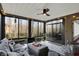 Bright sunroom featuring a ceiling fan, comfortable seating, and tranquil wooded views at 9334 Seascape Dr, Indianapolis, IN 46256