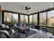 Relaxing sunroom with wicker seating, a ceiling fan, and views of the wooded backyard at 9334 Seascape Dr, Indianapolis, IN 46256