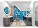Bright bathroom with dual sinks, black fixtures, a decorative ladder shelf, and a modern blue accent wall at 935 N Tacoma Ave, Indianapolis, IN 46201