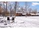 Seating overlooks the snow covered backyard and custom log home in a wooded setting at 98 Highland Manor S Ct, Indianapolis, IN 46228