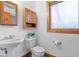 Classic bathroom featuring a pedestal sink, toilet, built in vanity, and a window for natural light at 98 Highland Manor S Ct, Indianapolis, IN 46228