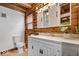 Rustic bathroom features log walls, white vanity with stone countertop, and a sliding barn door mirror at 98 Highland Manor S Ct, Indianapolis, IN 46228