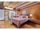 Charming log bedroom featuring hardwood floors and an adjacent bathroom at 98 Highland Manor S Ct, Indianapolis, IN 46228