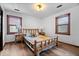 Cozy bedroom with natural wood bed frame, wood flooring and two windows at 98 Highland Manor S Ct, Indianapolis, IN 46228