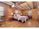 Cozy log bedroom with hardwood floors, wood ceiling beams, and natural light at 98 Highland Manor S Ct, Indianapolis, IN 46228