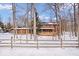 A Log home in a snowy wooded lot with a fenced yard and attached garage at 98 Highland Manor S Ct, Indianapolis, IN 46228