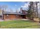 Log cabin-style home with well-kept green lawn, a stone chimney and mature trees at 98 Highland Manor S Ct, Indianapolis, IN 46228