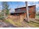 Log home with a stone chimney and green lawn with mature trees in a beautifully landscaped front yard at 98 Highland Manor S Ct, Indianapolis, IN 46228