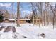 Log home with an attached garage and a beautifully maintained exterior in a snowy, wooded lot at 98 Highland Manor S Ct, Indianapolis, IN 46228