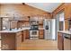 Rustic kitchen with stainless steel appliances, log walls, and wooden floors and cabinets at 98 Highland Manor S Ct, Indianapolis, IN 46228