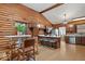 Rustic log cabin kitchen with wood walls, stainless steel appliances, and eat-in island at 98 Highland Manor S Ct, Indianapolis, IN 46228