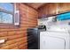 Laundry room featuring wooden walls, washer, and dryer near a window at 98 Highland Manor S Ct, Indianapolis, IN 46228