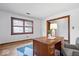Well-lit office space features wood trim, natural light, hardwood floors, and cozy desk at 98 Highland Manor S Ct, Indianapolis, IN 46228