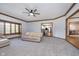Spacious carpeted living room featuring a ceiling fan, large window, and open access to the kitchen and dining area at 1143 N Sugar Bend Run, Greenfield, IN 46140