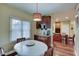 Bright dining area with natural light, leading into kitchen with wooden cabinets and granite countertops at 1401 Shadow Ct, Zionsville, IN 46077