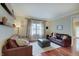 Cozy living room featuring hardwood floors, leather seating, and natural light at 1401 Shadow Ct, Zionsville, IN 46077