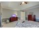 Bedroom featuring a tray ceiling, fan, neutral walls, and a wooden chest of drawers at 1401 Shadow Ct, Zionsville, IN 46077