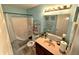 Cozy bathroom featuring a shower/tub combo, vanity with a large mirror, and blue walls at 1407 Aggie Ln, Indianapolis, IN 46260