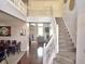 Grand two-story foyer featuring a staircase, hardwood floors, and views of the dining room and living area at 1407 Aggie Ln, Indianapolis, IN 46260