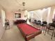Open-concept game room with a pool table, bar stools, and access to the dining area and main stairway at 1407 Aggie Ln, Indianapolis, IN 46260