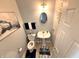 Stylish powder room with modern fixtures, decorative mirror, and attractive artwork at 1407 Aggie Ln, Indianapolis, IN 46260
