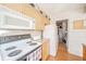 Functional kitchen design with bright appliances, light wood cabinets, and convenient access to the laundry at 142 Norbeck Ter, Indianapolis, IN 46217