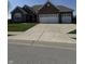 Charming single-story brick home with a spacious three-car garage and well-manicured lawn at 15085 Thoroughbred Dr, Fishers, IN 46040