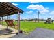 Relaxing backyard featuring an outdoor swing, with a well-maintained lawn and clear skies at 1585 S 600 W, New Palestine, IN 46163