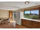Open kitchen area features a dining table, stainless steel refrigerator, and a large window offering scenic backyard views at 1585 S 600 W, New Palestine, IN 46163
